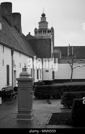 Giardino del Museo del Folklore, Balstraat, Brugge, Belgio: casette imbiancate del vecchio calzolai' Guild almshouse; versione in bianco e nero Foto Stock