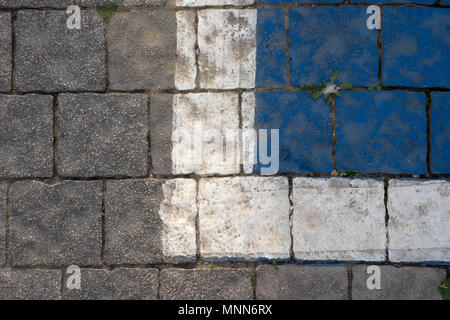 Sfondo astratto di un grigio pietra muro fatto di mattoni quadrati, con una striscia di colore bianco e un quadrato blu sulla parte superiore destra. Foto Stock