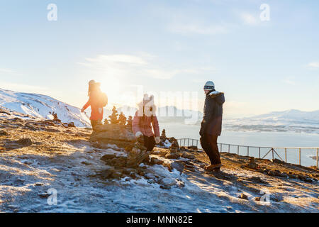 Bella famiglia della madre e bambini hanno un piacevole momento in inverno nevoso giorno all'aperto godendo di viste nei pressi di Tromso Norvegia Foto Stock