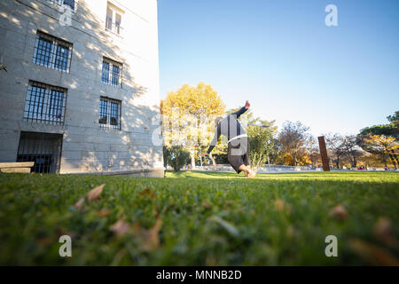 Giovane uomo facendo un incredibile parkour trucco nel parco. Foto Stock