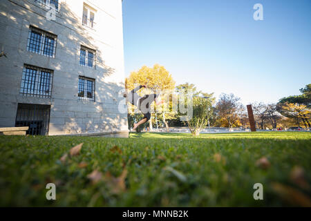 Giovane uomo facendo un incredibile parkour trucco nel parco. Foto Stock