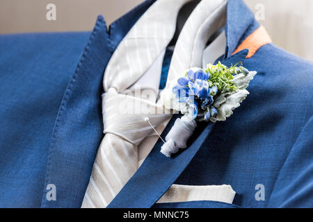 Uomini new marine blu navy indossare giacca e cravatta per lo sposo closeup con fiore boutonniere, pin ottenere pronto preparazione di nozze isolato, tasca fazzoletto Foto Stock