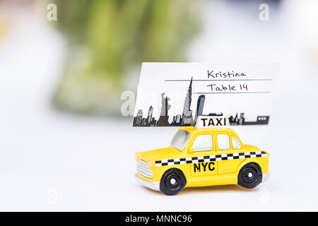 La città di New York, Stati Uniti d'America - 7 Aprile 2018: NY NYC giallo taxi souvenir carino piccolo giocattolo auto bomboniera dono decorazioni sul tavolo della reception panno bianco c Foto Stock