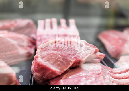 Rosa rosso carne cruda agnello su gambi, con osso osso nel display del negozio, vassoi per la vendita, rack di grassi Foto Stock