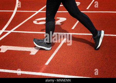Femmina atletico gambe e scarpe di sport donna jogging sulla gara di corsa Foto Stock