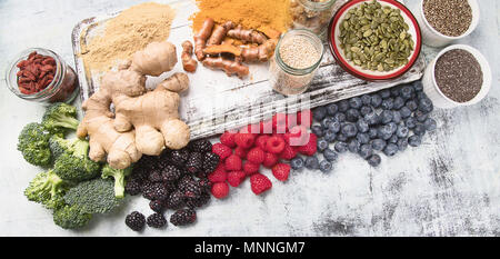 Varie superfoods su bianco tavola di legno. Cibo sano concetto Foto Stock