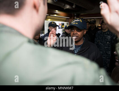 NORFOLK, Virginia (Mar. 16, 2018) -- Aviazione di Boatswain Mate (attrezzature) Airman Abriel Thomas, da Groesbeck, Texas, assegnato alla USS Gerald Ford (CVN 78) aria reparto, recita il giuramento di arruolamento data dal Lt. Adam Boyd durante la sua cerimonia reenlistment. Foto Stock