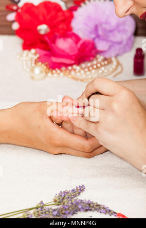 L'applicazione di smalto per unghie su una donna di mani Foto Stock