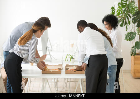 Vista posteriore al corporate dipendenti del team pizza di Condivisione in ufficio Foto Stock