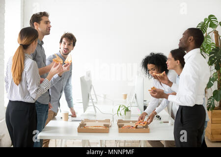 Gentile diversi team di business parlando di mangiare la pizza insieme in Foto Stock