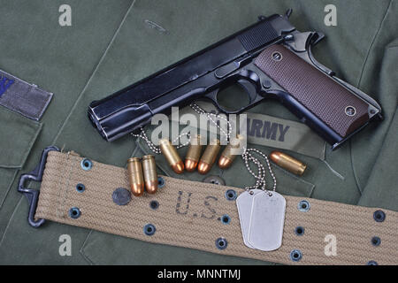 Governo colt M1911 con US Army tessitura uniforme sullo sfondo Foto Stock