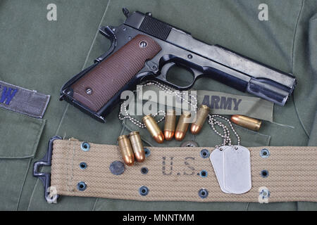 Governo colt M1911 con US Army tessitura uniforme sullo sfondo Foto Stock