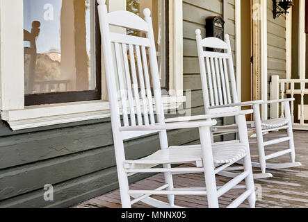 Legno sedie a dondolo sul portico anteriore di un victoran home sotto il restauro Foto Stock