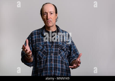 Studio shot di gangster maturo uomo con braccia alzate Foto Stock