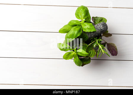 Le erbe fresche all'interno della pietra pestello e mortaio Foto Stock