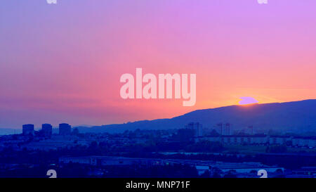 Glasgow, Scotland, Regno Unito 18 maggio.UK Meteo: tempo soleggiato dando modo al cloud vede un tramonto spettacolare nella zona ovest della città oltre la Kilpatrick hills con Drunchapel, Hardgate e Faifley in ombra. Le torri di Clydebank davanti a Erskine Bridge diventano semplici sagome. Gerard Ferry/Alamy news Foto Stock