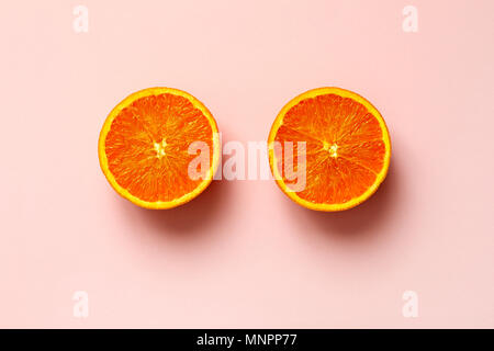 Frutta di arancia. Mezza arancia a fette di frutta isolare su sfondo rosa visto da sopra flatlay stile, vicino. Foto Stock