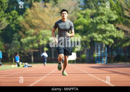 Giovane uomo asiatico atleta maschio esegue la formazione esercita sulla via. Foto Stock