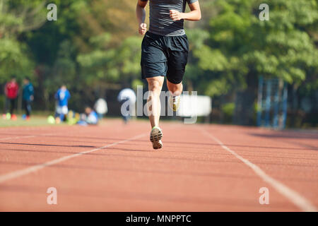 Giovane uomo asiatico atleta maschio esegue la formazione esercita sulla via. Foto Stock