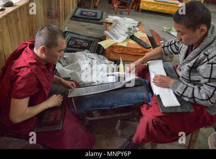 I monaci rendendo la carta a mano scritture e stampe di woodblock all'interno della sacra Scrittura Bakong Stampa Monastero a Dege, Sichuan, in Cina Foto Stock