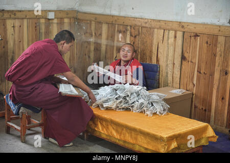 I monaci rendendo la carta a mano scritture e stampe di woodblock all'interno della sacra Scrittura Bakong Stampa Monastero a Dege, Sichuan, in Cina Foto Stock