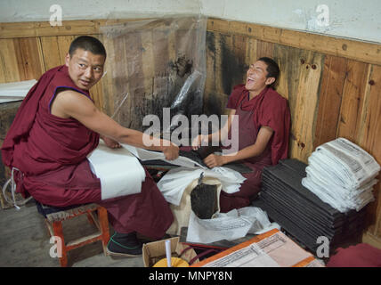 I monaci rendendo la carta a mano scritture e stampe di woodblock all'interno della sacra Scrittura Bakong Stampa Monastero a Dege, Sichuan, in Cina Foto Stock