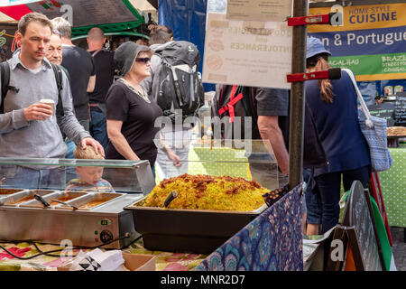 Isolato e immagini dettagliate di un cibo asiatico visto di stallo entro un mercato all'aperto nel Regno Unito. Riso e altre salse può essere visto pronti a servire. Foto Stock