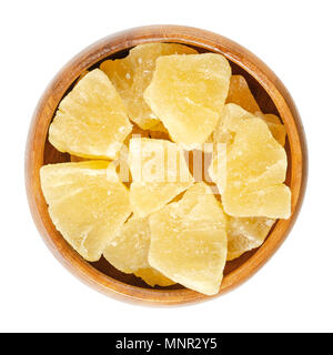 I canditi di pezzi di ananas in ciotola di legno. Cristallizzato pezzi di Ananas comosus. Colorato in giallo carne delle conserve di frutta con zucchero. Snack. Foto Stock