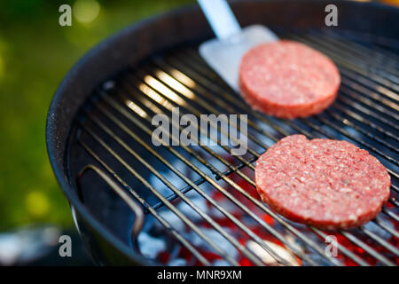 La grigliatura burger costolette di carne per hamburger fatti in casa per la cottura all'aperto sul giorno di estate Foto Stock