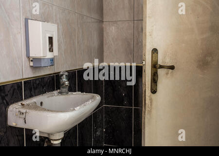 Interno di un vecchio edificio in rovina, abbandonato sporco wc camera Foto Stock