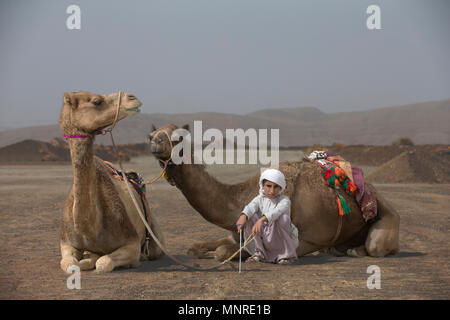 AL Safen, Oman, 27 Aprile 2018: ragazzo beduino con i suoi cammelli nella campagna dell'Oman Foto Stock