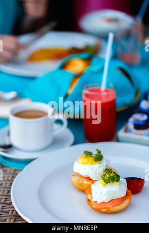 Deliziosa colazione a buffet con uova Benedict, verdura e caffè Foto Stock