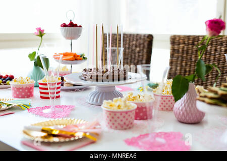 Torta, caramelle, marshmallows, popcorn, frutta e altri dolci sulla tavola da dessert a kids festa di compleanno Foto Stock