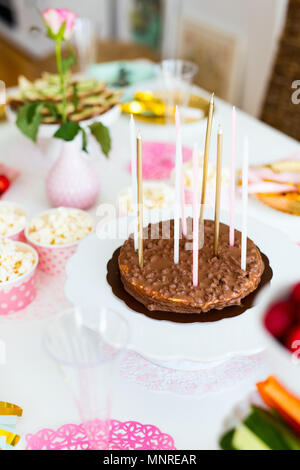 Torta, caramelle, marshmallows, popcorn, frutta e altri dolci sulla tavola da dessert a kids festa di compleanno Foto Stock