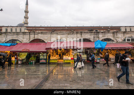 Gli amanti dello shopping a piedi le strade piovose di navigare all'aperto le bancarelle del mercato che hanno versato all'esterno dall'interno di Istanbul Bazar delle Spezie in Turchia Foto Stock