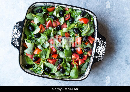 Purslane con insalata di pomodori e olive nere in vaso di porcellana. Alimenti biologici. Foto Stock