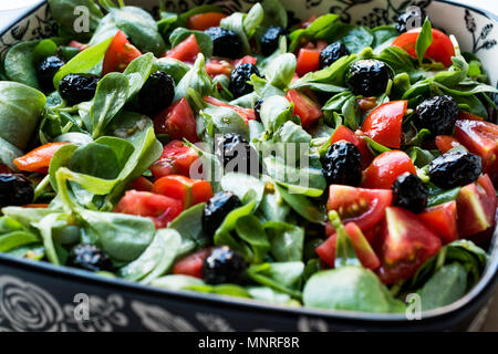 Purslane con insalata di pomodori e olive nere in vaso di porcellana. Alimenti biologici. Foto Stock