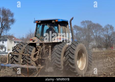 South Elgin, Illinois, Stati Uniti d'America. L'agricoltore utilizza un trattore per preparare i suoi campi prima la molla entra in planata. Foto Stock