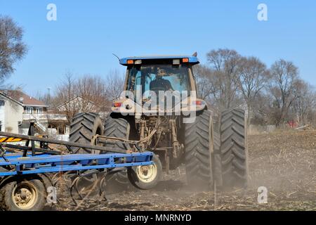 South Elgin, Illinois, Stati Uniti d'America. L'agricoltore utilizza un trattore per preparare i suoi campi prima la molla entra in planata. Foto Stock