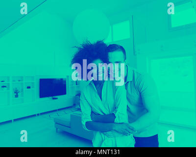 Giovane e bella coppia multietnica abbracciando nel loro nuovo appartamento Foto Stock