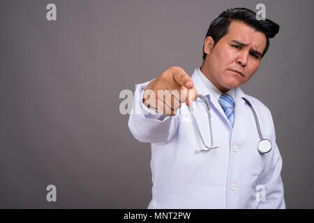 Giovani multi-etnico medico uomo contro uno sfondo grigio Foto Stock
