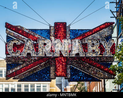 Giant sequinned Unione Jack segno pende su Londra famosa Carnaby Street fashion street nel West End di Londra Foto Stock