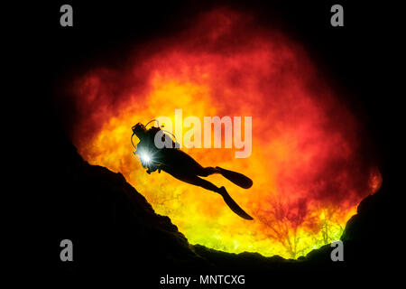 Donna scuba diver, esplorando Devil's Eye grotta, dove il rigonfiamento in acqua dolce chiaro viene miscelato con abbronzata, acqua organica da Santa Fe River, Ginnie Primavera Foto Stock