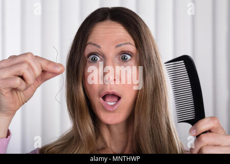 Scioccato la donna che soffre di perdita di capelli problema Foto Stock