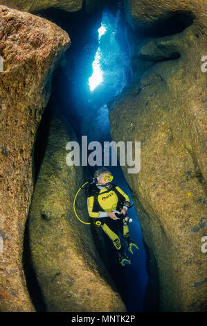 Donna scuba diver, esplorando caverne di Comino, o Santa Marija Grotte, Comino, Gozo, Malta, Mar Mediterraneo, Oceano Atlantico, signor Foto Stock