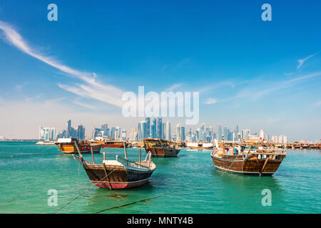 Waterfront a Doha in Qatar con legno tradizionali di piccole navi noto come dhow e dello skyline della città Foto Stock