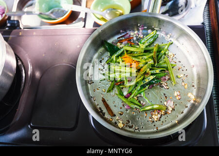 Preparazione di tradizionali dello Sri Lanka il piatto con i fagiolini verdi a lezioni di cucina Foto Stock