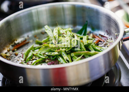 Preparazione di tradizionali dello Sri Lanka il piatto con i fagiolini verdi a lezioni di cucina Foto Stock