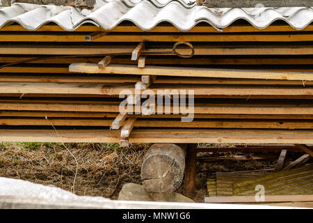 Pila di una pila di legname. Essiccato di pannelli di legno con una crepa. Diversi tipi di legno. Coperto con ardesia. Close-up. Foto Stock