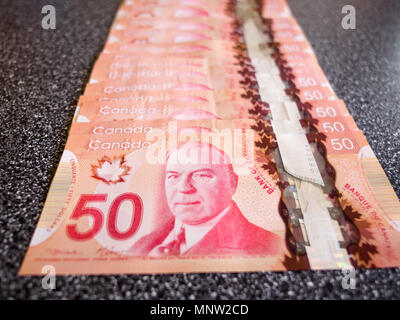 Una linea del canadese 50 fatture del dollaro: una lunga linea di cinquanta Canadian Dollar Bills disteso su un contatore. Foto Stock